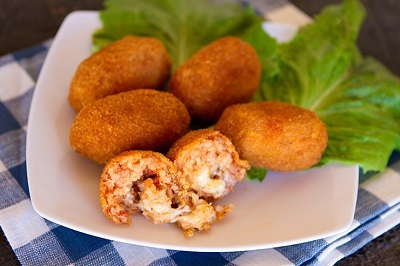 Suppli opened up to show rice mixture, meat, and melty cheese.