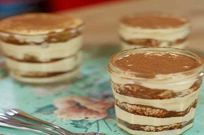 Layers of coffe flavored tiramisu in a cup.