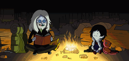 A gif from Adventure Time, in which two characters read a book around a campfire
