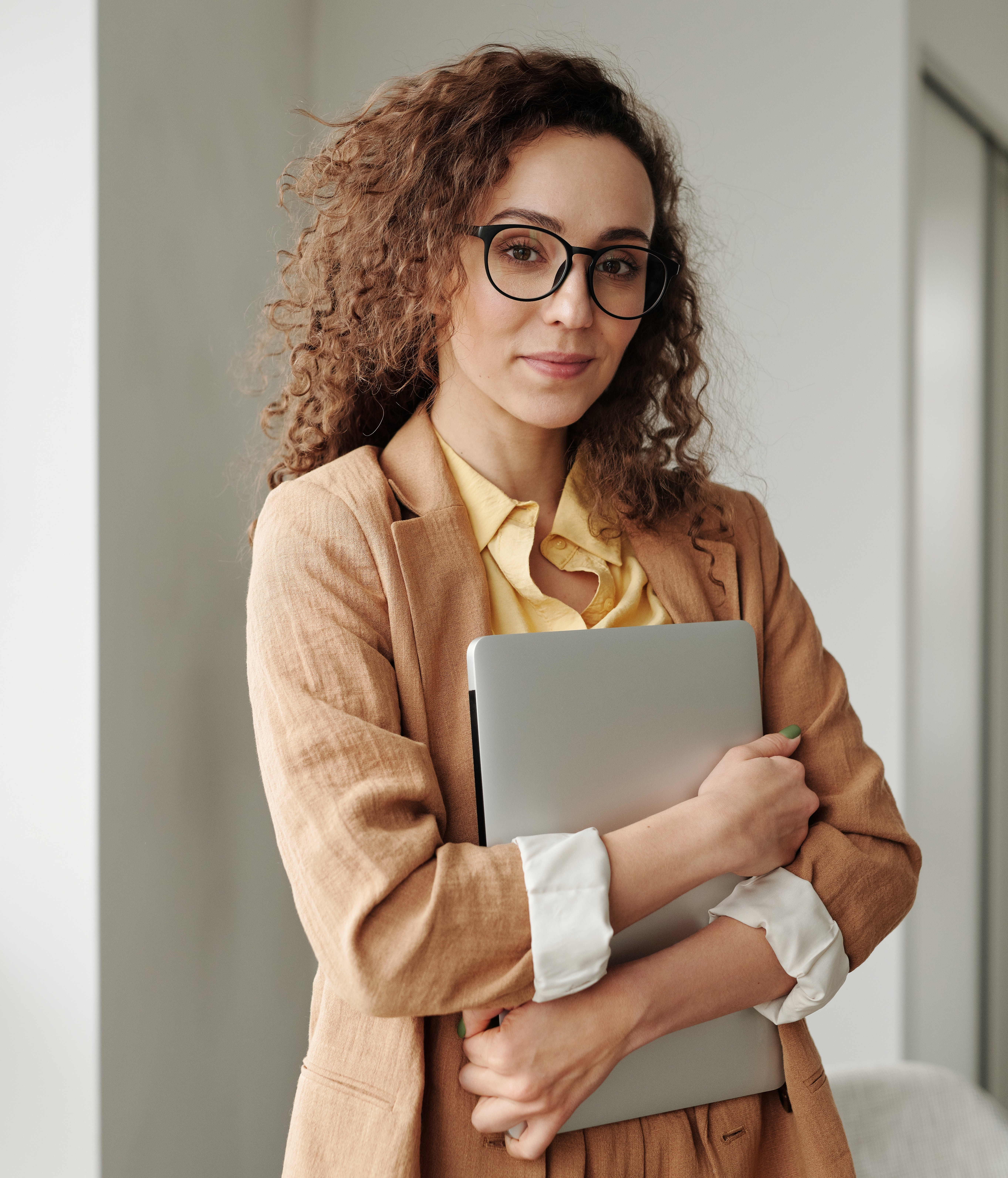 young woman in beige suit holding documents